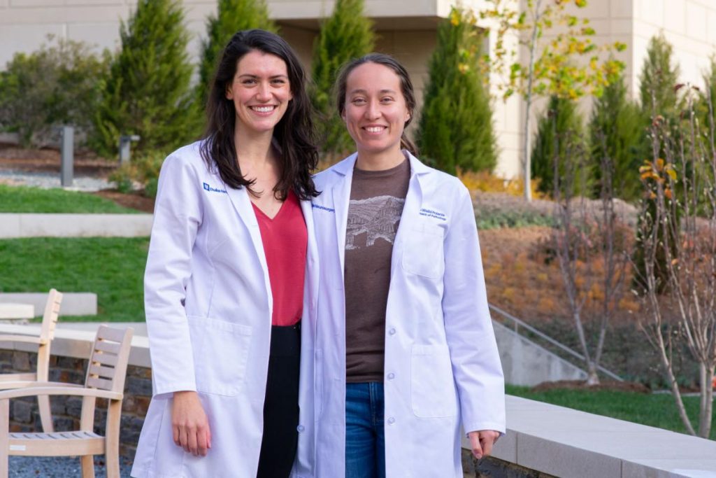 Portrait of the two students outside in their lab coats